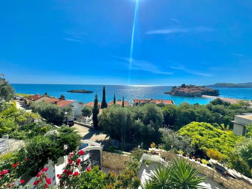 a view of a town with the ocean in the background at Sun Rose Apartments Sveti Stefan in Sveti Stefan