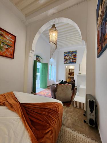 um quarto com uma cama e uma sala de estar em Dar Adul em Essaouira