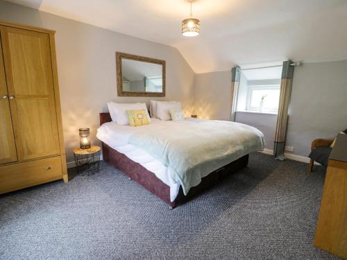 um quarto com uma cama grande e um espelho em Rhydygaled em Llanarmon-Mynydd-mawr