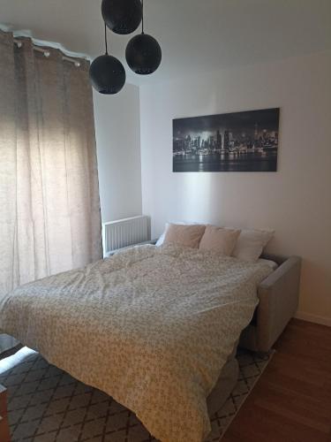 - une chambre avec un lit et deux lampes pendant dans l'établissement Studio tout confort Massy-Paris, à Massy