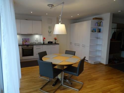 - une cuisine et une salle à manger avec une table et des chaises dans l'établissement ZISA Ferienwohnung Bodensee, à Friedrichshafen