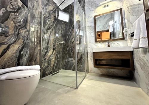 a bathroom with a shower and a toilet and a sink at AQUA MARINN SPA&WELLNESS in Yalova