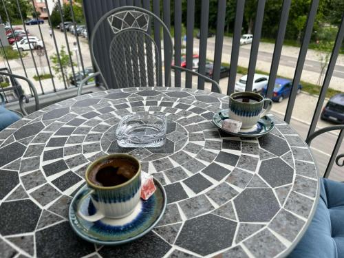 two cups of coffee on a table on a balcony at Violet deluxe in Niš
