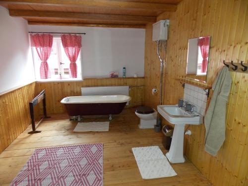 ein Badezimmer mit einer Badewanne, einem WC und einem Waschbecken in der Unterkunft Drevenica 66 in Ždiar