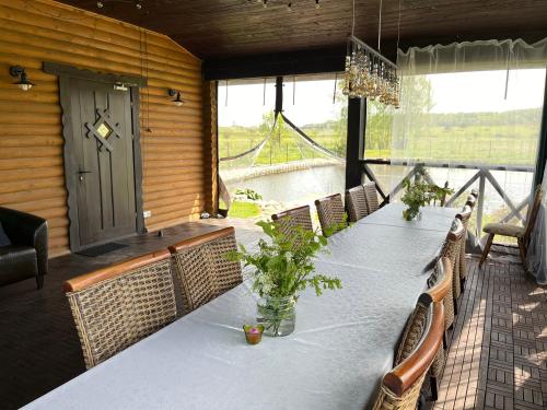 Vila Trakai في تراكي: غرفة طعام مع طاولة وكراسي طويلة