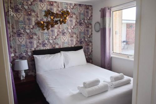 a bedroom with a bed with towels on it at Family Chalets - 5 mins walk to beach, nr Great Yarmouth & Norfolk Broads in Scratby