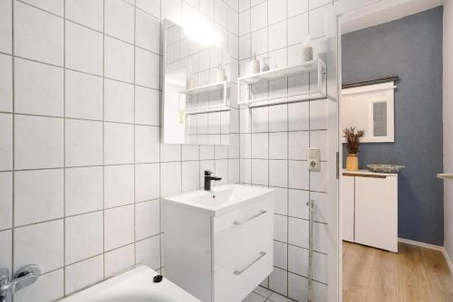 een witte badkamer met een wastafel en een spiegel bij Appartmenthaus - Wohnung C in Plauen
