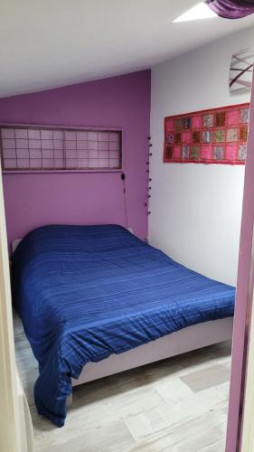 une chambre avec un lit avec une couette bleue dans l'établissement Maisonnette près de Paris et de l'aéroport d'Orly, à Villeneuve-le-Roi