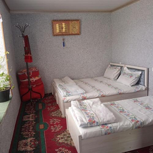 Habitación con 2 camas y alfombra roja. en Barlos Oromgohi 