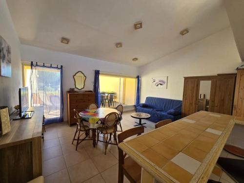 un salon avec une table et un canapé bleu dans l'établissement Cap d'Agde proche port et plage, au Cap d'Agde