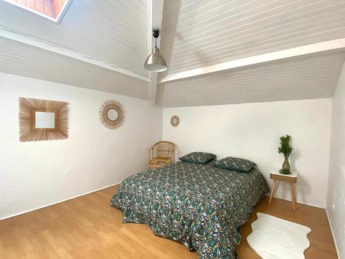 une chambre avec un lit dans une pièce blanche dans l'établissement Maison landaise de famille, à Josse