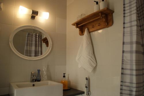 ein Bad mit einem Waschbecken und einem Spiegel in der Unterkunft Maalaishotelli Hanna&Magnus in Merikarvia