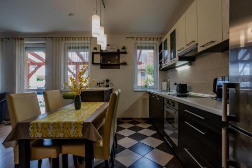 a kitchen with a table with chairs and a dining room at Six Corners Sunny Corner Apartment with Terrace in Pécs