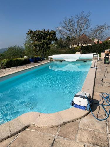 une piscine bleue avec un aspirateur dedans dans l'établissement Maison entière et spacieuse Gîte Dovie, à Château-Thierry