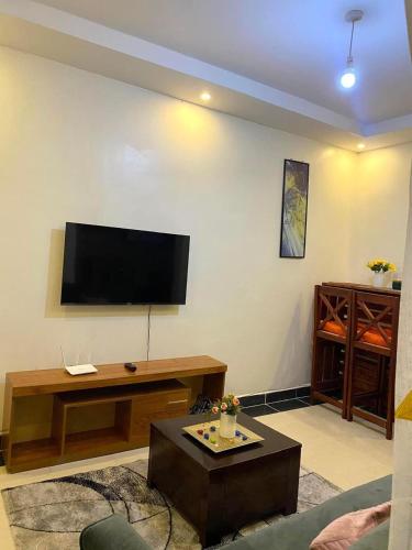 a living room with a flat screen tv on the wall at Thika Furnished Apartments in Thika