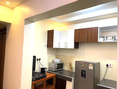 a kitchen with a refrigerator and a microwave at Thika Furnished Apartments in Thika