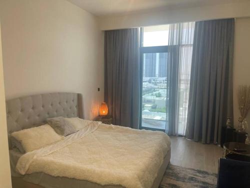 a bedroom with a bed and a large window at Luxury Studio l Burj Khalif View in Dubai