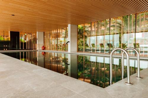 a pool in the middle of a building with windows at Hotel Jakarta Amsterdam in Amsterdam