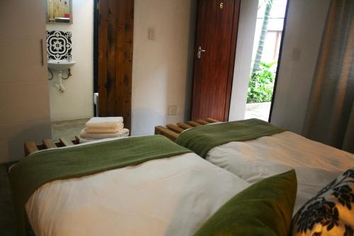 two beds in a room with a window at The Residence at Villa Wiese in Swakopmund