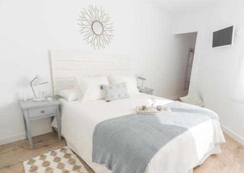 a white bedroom with a bed with a tray on it at Ático Chic Fontes junto a la Catedral in Murcia