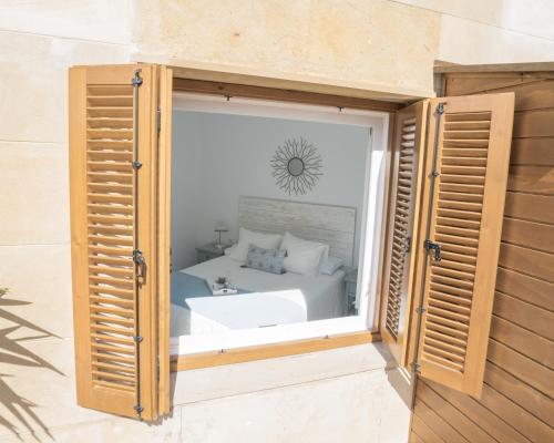 ein großes Fenster mit einem Bett in einem Zimmer in der Unterkunft Ático Chic Fontes junto a la Catedral in Murcia