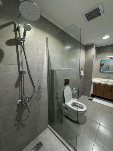 a bathroom with a shower with a toilet and a sink at Tamimi Geshla Residency in Al Khobar