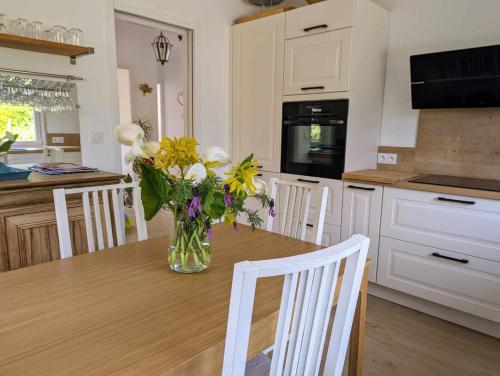 a vase of flowers sitting on a table in a kitchen at La Sapinière in Perros-Guirec