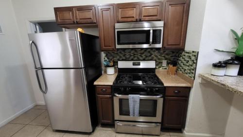 eine Küche mit einem Kühlschrank aus Edelstahl und einer Mikrowelle in der Unterkunft U1 - Entire 2 BR Pet Friendly APT in DT PHX with pkg in Phoenix