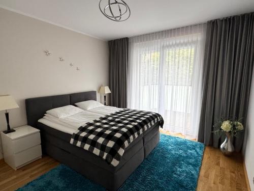 ein Schlafzimmer mit einem Bett und einem großen Fenster in der Unterkunft River Deluxe Atal Towers Apartment in Breslau