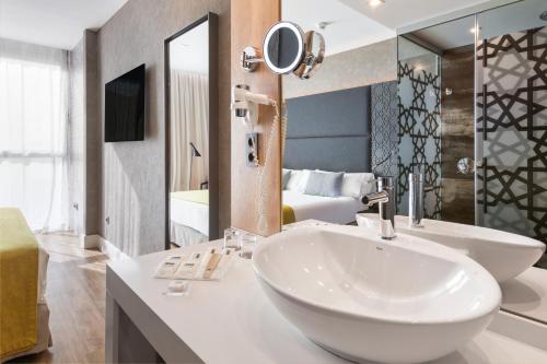 La salle de bains est pourvue d'un lavabo et d'un grand miroir. dans l'établissement Catalonia Giralda, à Séville