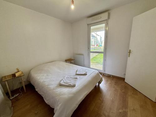 1 dormitorio con 1 cama con 2 toallas en *Esprit Littoral* T2 Terrasse Parking Wifi, en Quimper