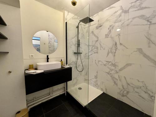y baño con ducha, lavabo y espejo. en *Esprit Littoral* T2 Terrasse Parking Wifi, en Quimper