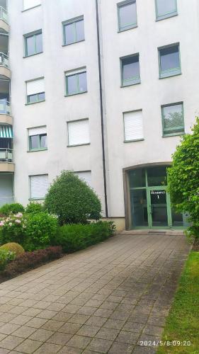 un gran edificio blanco con una pasarela delante de él en QUIET PEACEFUL 2BR apartment with parking in KIRCHBERG, en Luxemburgo