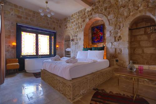 a bedroom with a large bed and a bath tub at Şems Inn in Mardin