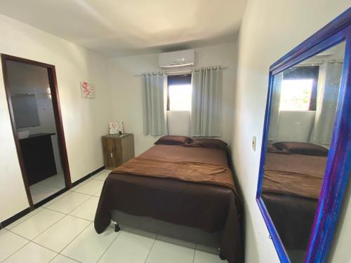 een slaapkamer met een bed en een grote spiegel bij SANNY Pousada e Hostel in Pipa
