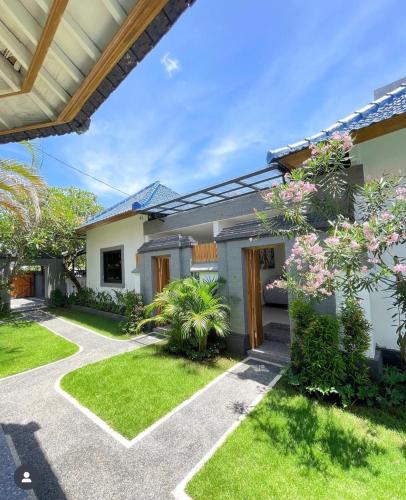 a house with a garden and a pathway at THE SUN BALI VILLA’S in Kuta