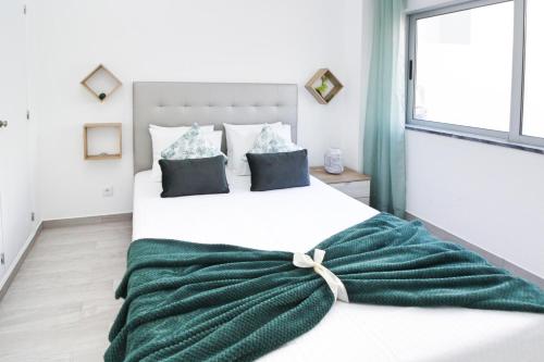sypialnia z dużym łóżkiem i zielonym kocem w obiekcie Apartment Panorama Green w mieście Portimão