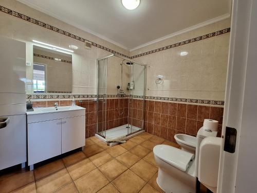 a bathroom with a toilet and a sink and a shower at Amazing Studio with Ocean View, Pool and Beach in Lagos