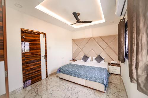 a bedroom with a bed and a ceiling fan at Staeg Cozy Penthouse 2BHK in Indore