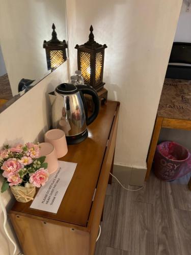 曼谷的住宿－拉羅坎達酒店，木桌上的茶壶,上面有鲜花