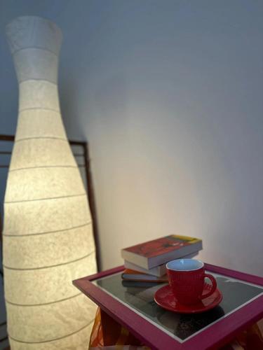 a table with a cup and books and a lamp at Le Casette dei Nonni in Alviano
