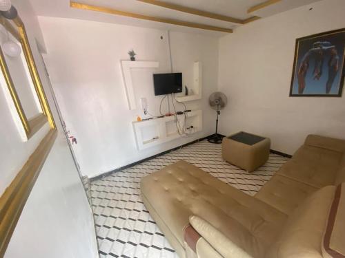 ein Wohnzimmer mit einem Sofa und einem TV in der Unterkunft Biji Paradise Hotel in Benin City