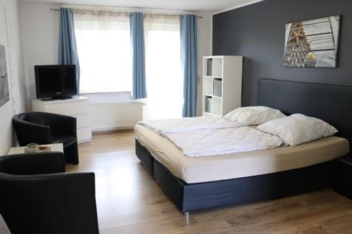 a bedroom with a bed and a television in it at Apartmenthaus Wattwurm in Friedrichskoog