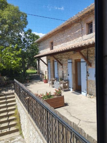 a stone house with a fence and a staircase at La Plume in Orgnac-lʼAven