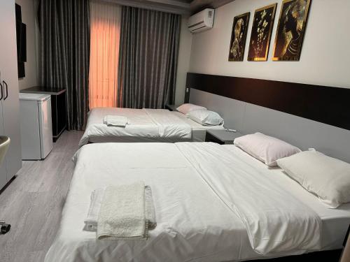 2 łóżka w pokoju hotelowym z białą pościelą w obiekcie Retrol Hotel w Stambule