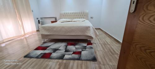 1 dormitorio con cama y alfombra en el suelo en duplex avec jardin, en Dar el Haj Ahmed Souid