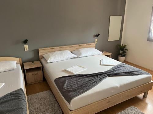 um quarto com uma cama com lençóis brancos e almofadas em Apartmani Italo em Biograd na Moru