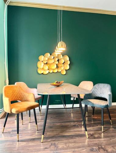 a dining room with a green wall and a table and chairs at STADtPERLE in Itzehoe