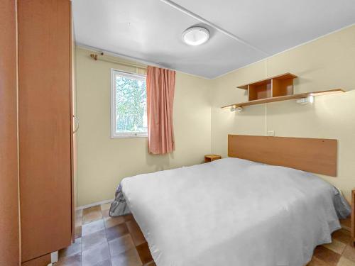 une chambre avec un lit blanc et une fenêtre dans l'établissement Grands Espaces et Nature à Sarlat N83, à Sarlat-la-Canéda