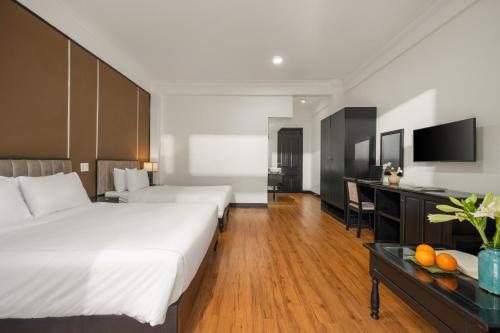 um quarto de hotel com duas camas e uma secretária em Kly Boutique Hotel em Hue